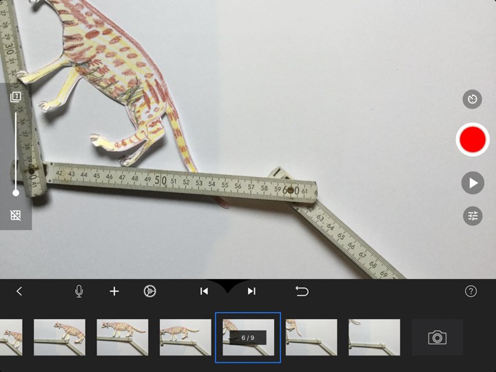 Das Foto zeigt die Erstelloberfläche in der App "Stop Motion Studio". Der Regler ganz links ist so weit nach unten geschoben wie möglich. Das sechste von neun möglichen Einzelbildern ist ausgewählt. Am linken Bildrand liegt der Ausschnitt von einer Ginsterkatze.